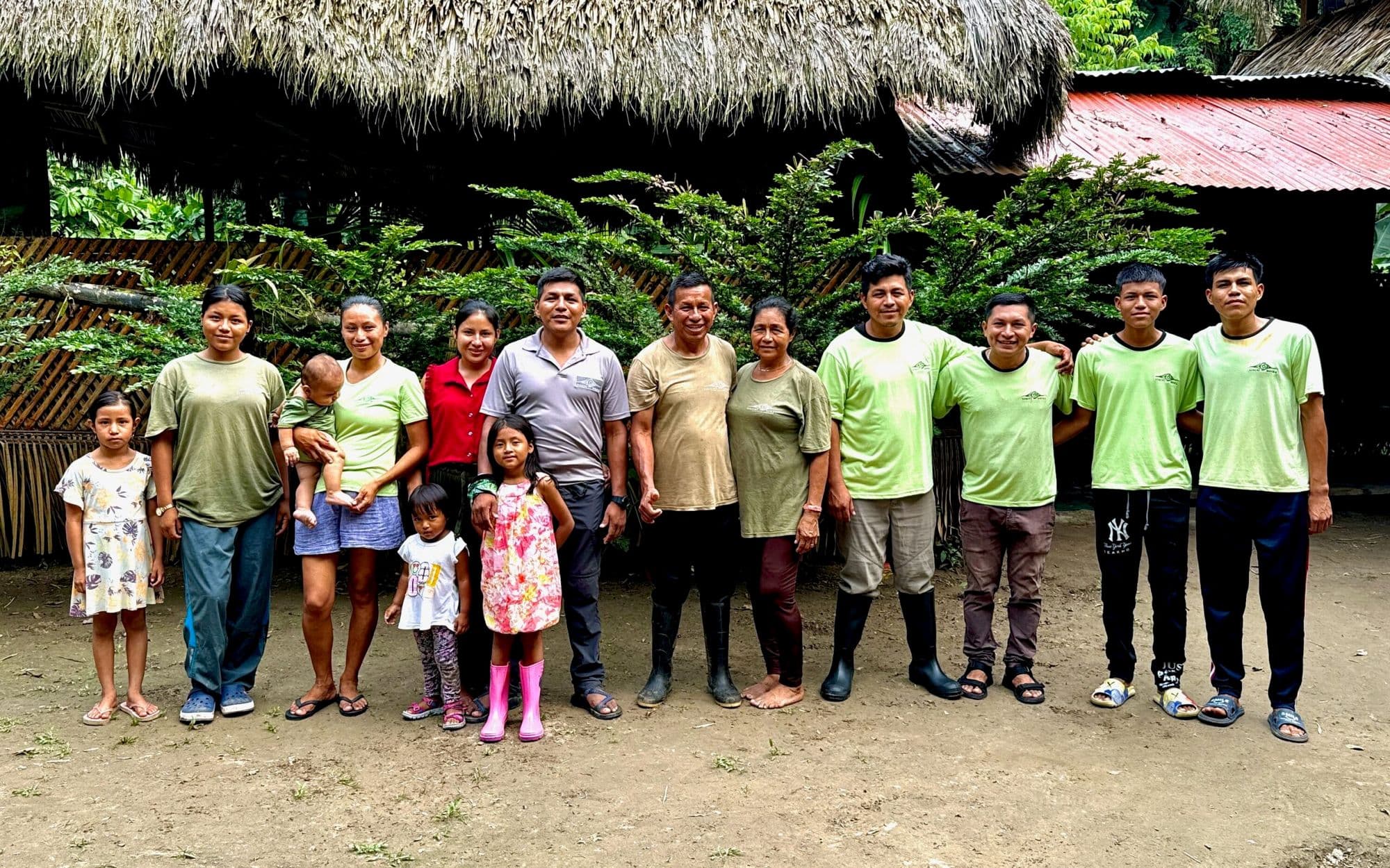 El personal y la familia del eco-lodge Sinchi Wayra posando juntos en el Parque Nacional Yasuní, Ecuador.